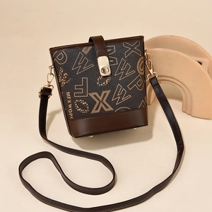Chic brown bucket bag with monogram print and golden hardware on a minimal background