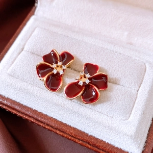 Macro view of 18K gold plated dark red floral stud earrings with cubic zirconia