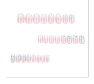 Detail of 24pcs pink gradient press-on nails with blue flowers and pearl accents