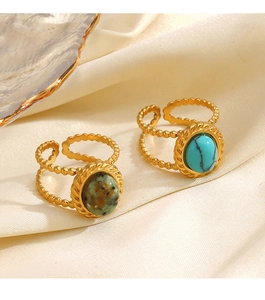 Detail of adjustable gold rings with turquoise and marble stone on silk fabric