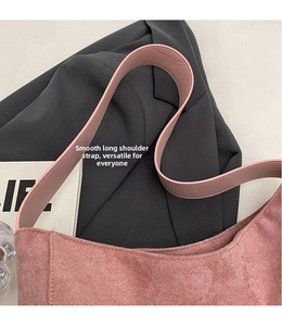 Detail der rosa Wildleder-Tasche mit glattem Schultergurt und weicher, matter Textur
