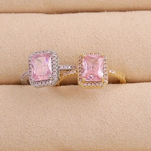 Pink rectangular zircon rings in gold and silver finishes on beige velvet display