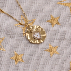 Golden necklace with heart pendant and star patterned background in high resolution