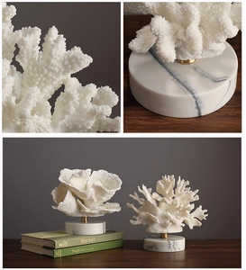 Detailed view of white resin coral decor on marble base with gold metal accents