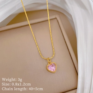 Close-up of gold heart pendant necklace with pink gemstone on a jewelry box display