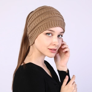 Detail of khaki cable knit headband for ponytails showing thick wool texture on a model