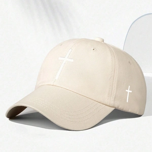 Close-up of white cross embroidery on a beige cotton twill baseball cap with air vents