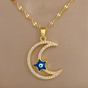 Detail of gold crescent moon and blue enamel star pendant with evil eye motif