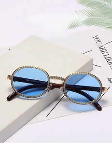 Detail view of round vintage sunglasses with gold frame and crystal rhinestones