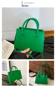 Detailed view of a green retro crossbody bag with handles and adjustable shoulder strap