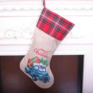Christmas stocking with vintage blue truck and gnome hung on a white fireplace