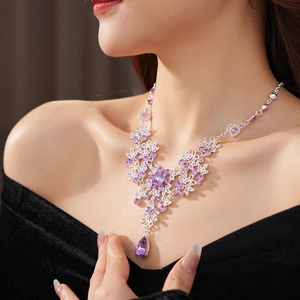 Detail of silver vintage necklace with purple zircon flower and pear-shaped pendant drop