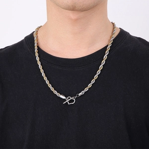Detail einer zweifarbigen gold-silbernen Kordelkette mit herzförmigem OT-Verschluss