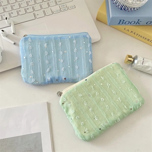 Detailed view of chiffon mesh coin pouches with sequins and lace trim in blue and green
