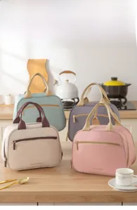 Detail showing various colors of insulated lunch bags with TASTY FOOD print on kitchen counter