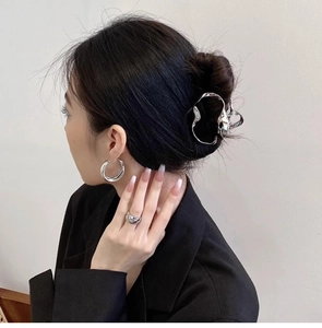 Close-up of irregular silver cloud hair claw clip with matching earrings on a model
