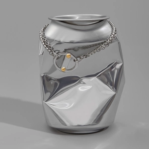 Detail of silver Cuban chain wrapped on a crushed can showing industrial toggle clasp