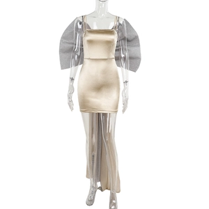 Détail d'une robe en satin champagne avec un grand nœud en paillettes argentées et traîne