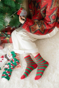 Detail of red and green striped Christmas coral fleece socks for winter warmth