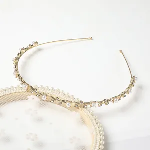 Detail of slim gold headband with pearls and crystals on a decorative lace pad