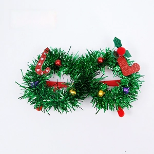 Close-up of green tinsel Christmas glasses with candy cane and festive stocking details