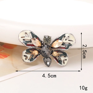 Detail view of a 4.5cm butterfly brooch with white enamel wings and sparkling crystals