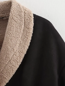 Detail of black suede jacket featuring contrast beige faux shearling collar and texture