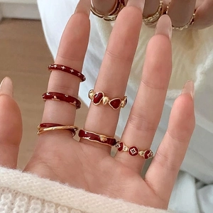 Vintage gold and dark red enamel flower open rings set worn on a female hand