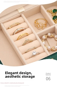 Detail of multi-slot velvet jewelry box showing gold rings and pearl brooch storage