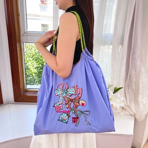 Detailed embroidery on purple lavender canvas tote bag with woven shoulder strap