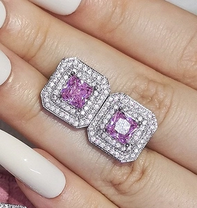 Close-up of square pink zircon stud earrings with double halo white stones in silver