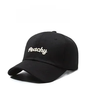 Close-up of white Peachy embroidery on a premium black cotton baseball cap