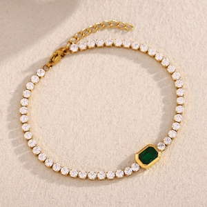 Detail of 18K gold-plated tennis bracelet with green emerald and white cubic zirconia