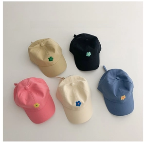 Vue à plat de cinq casquettes en coton pour enfants avec broderies florales colorées en couleurs