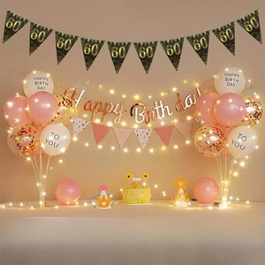 Detail of 60th birthday party set with black gold banners and LED string lights