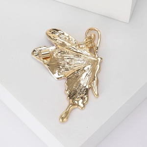 Back view of elegant enamel butterfly brooch showing golden metal texture and secure pin clasp