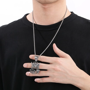 Macro view of winged skull pendant and square weave chain on a male model
