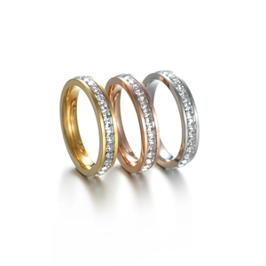 Macro shot of three stacked rings in gold, rose gold, and silver with square-cut zircons
