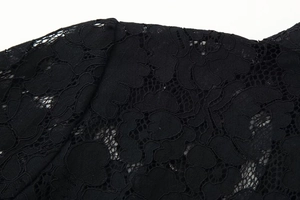 Gros plan sur le motif de dentelle noire et la broderie du col montant de la chemise
