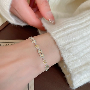 Detail of flower enamel bracelet on wrist with intricate hollow metal craftsmanship