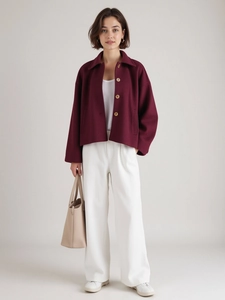 Full view of women's burgundy casual short jacket styled with wide white pants and tote bag