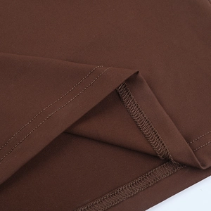 Vue macro détaillée de l'ourlet à double couture et de la texture de la robe en dentelle marron