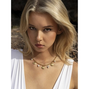 Detail of 18k gold plated starfish and shell pendants on a bohemian ocean style necklace