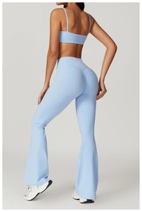 Detail of light blue cross-back yoga bra and flared leggings on an athletic fit female