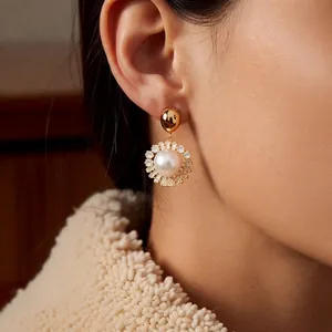 Elegant gold plated pearl drop earrings with sparkling zircon halo on female model