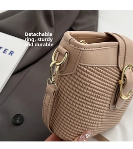 Detail of beige woven texture and leather splicing with golden metal buckle on handbag