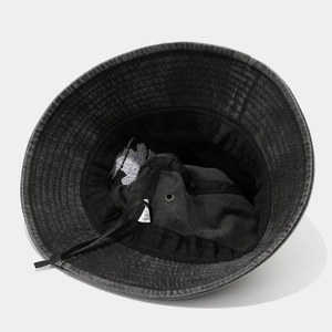 Detailed view of black washed cotton bucket hat interior with drawstring and air vents