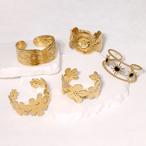 Set of five gold stainless steel bangles featuring floral and geometric designs on stone