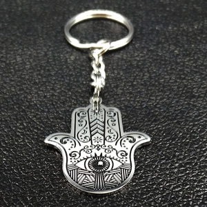 Detailed close-up of a silver stainless steel Hamsa Hand keychain with intricate engraving