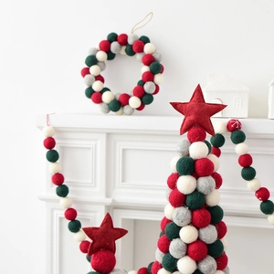 Handmade wool felt ball Christmas tree ornaments and wreath on white mantelpiece